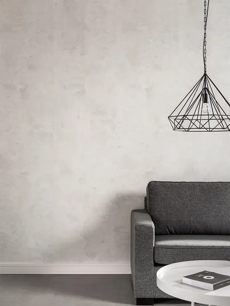 salon z betonową ścianą w odcieniach beżu